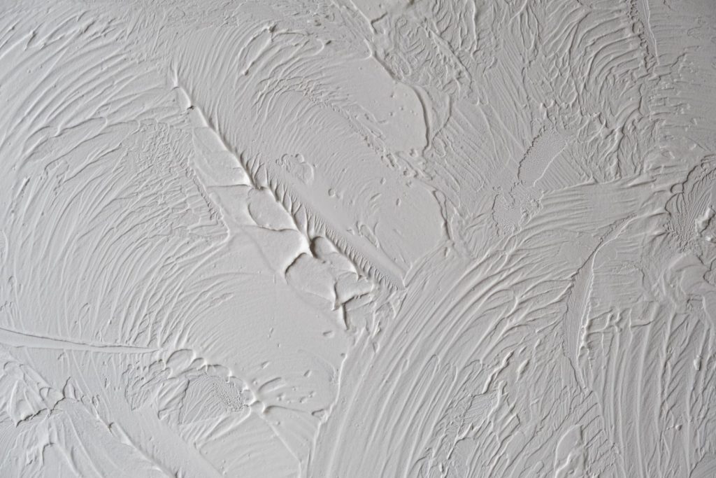 Close-up of textured drywall surface, showcasing abstract patterns created by drywall services.