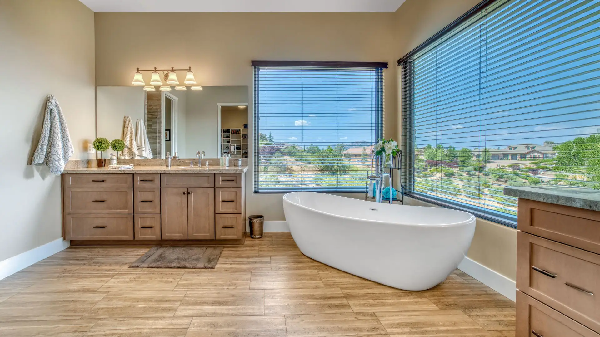 Master bathroom with a tub and big windows.